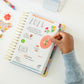 Floral sticker being placed on planner