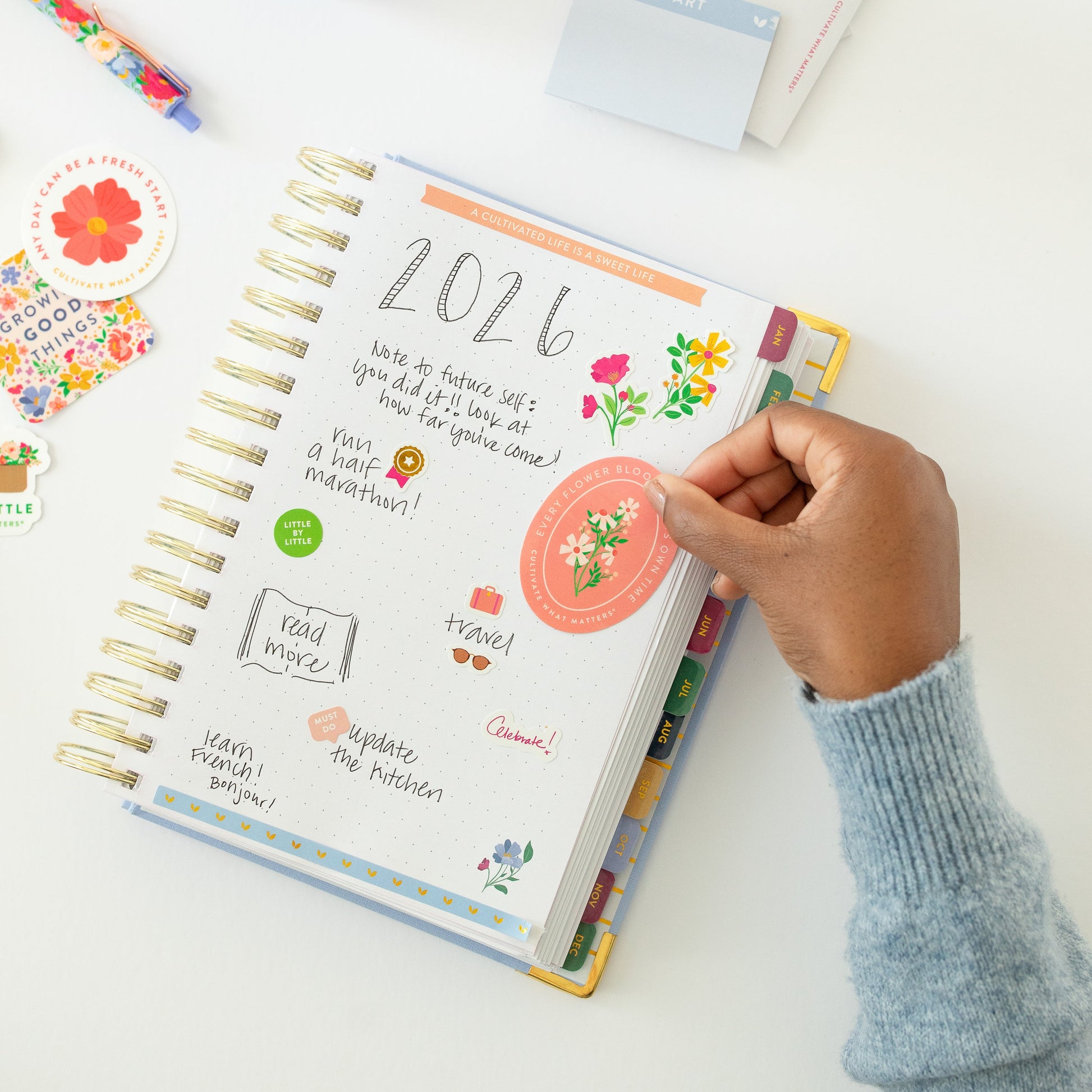 Floral sticker being placed on planner
